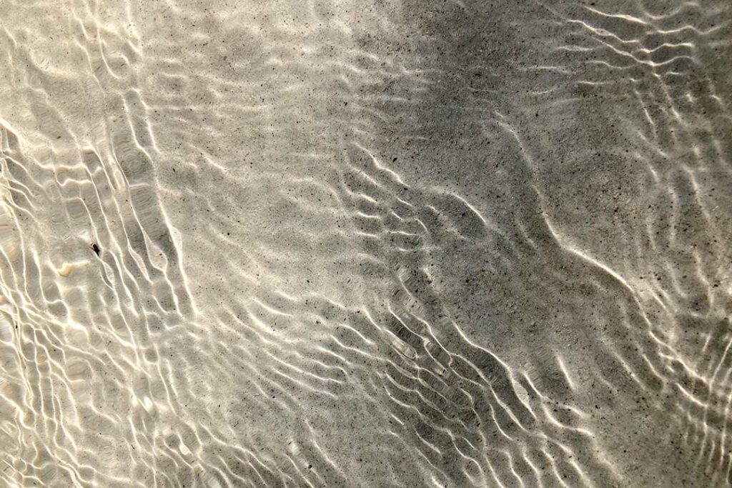 Sanfte Wellen gleitet über feinen Sandstrand